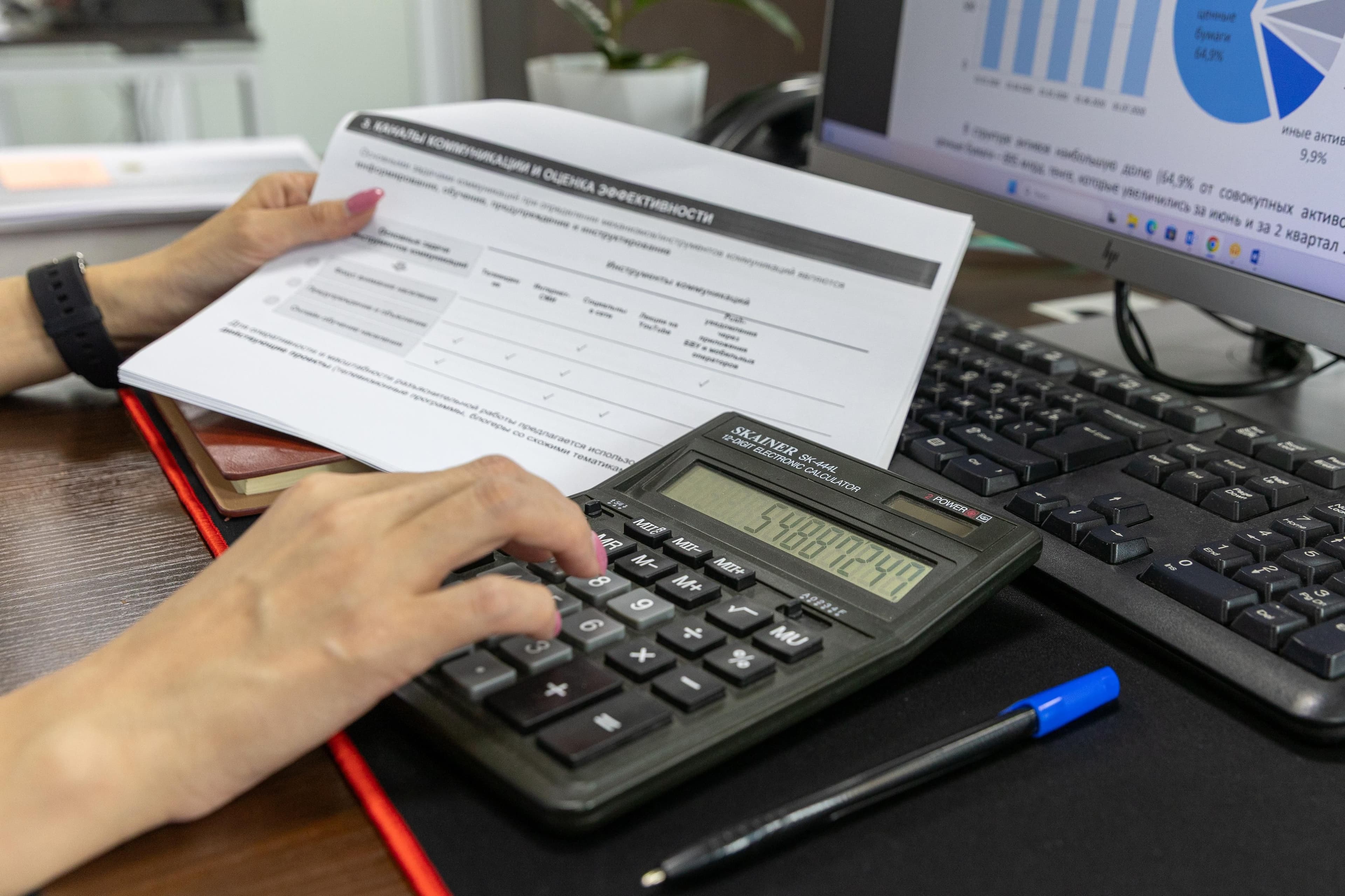 Contador analisando documentos contábeis com calculadora