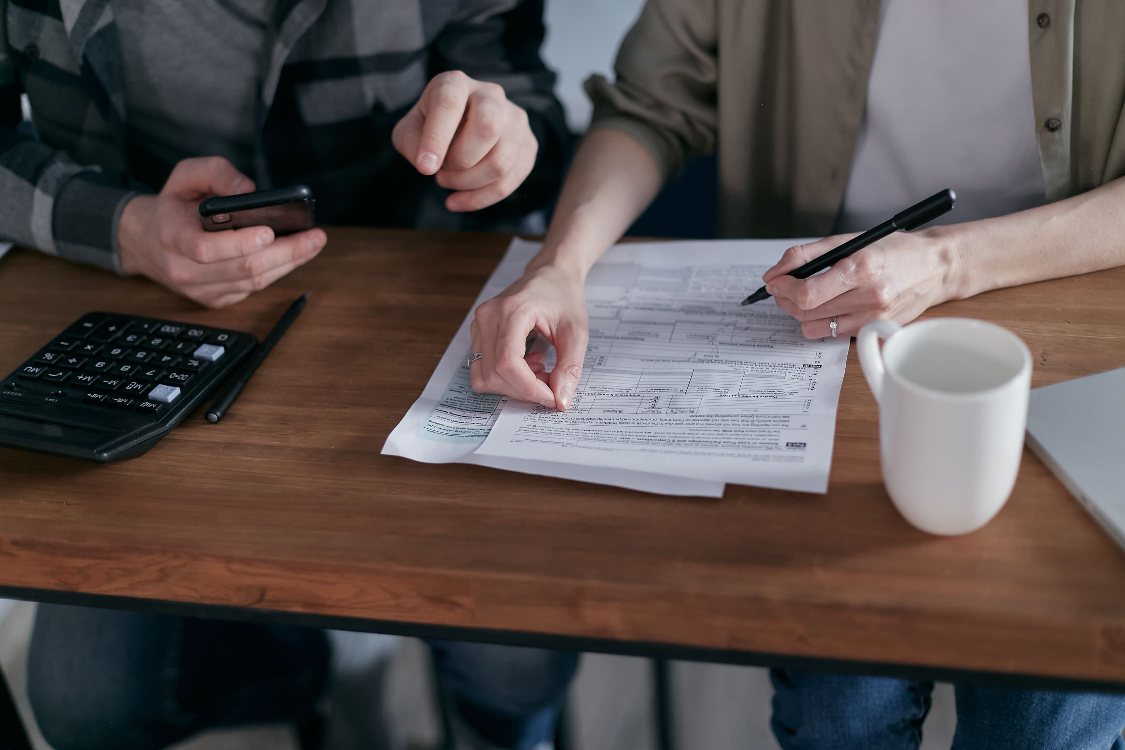 Documentos e calculadora sobre a mesa durante atendimento societário